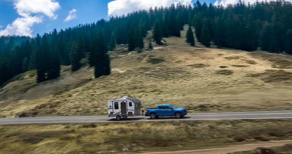 2025 Ford Maverick XLT pulling a camper through the mountains