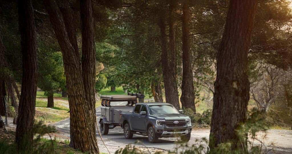 2025 Ford Ranger driving down the street, through the trees, with a hitch attached