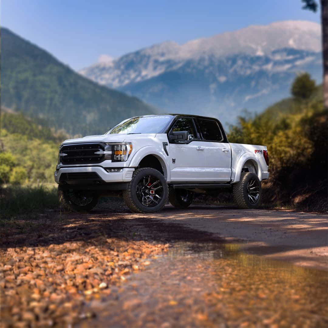 Rocky Ridge Custom Ford Truck parked in the mountains by a stream