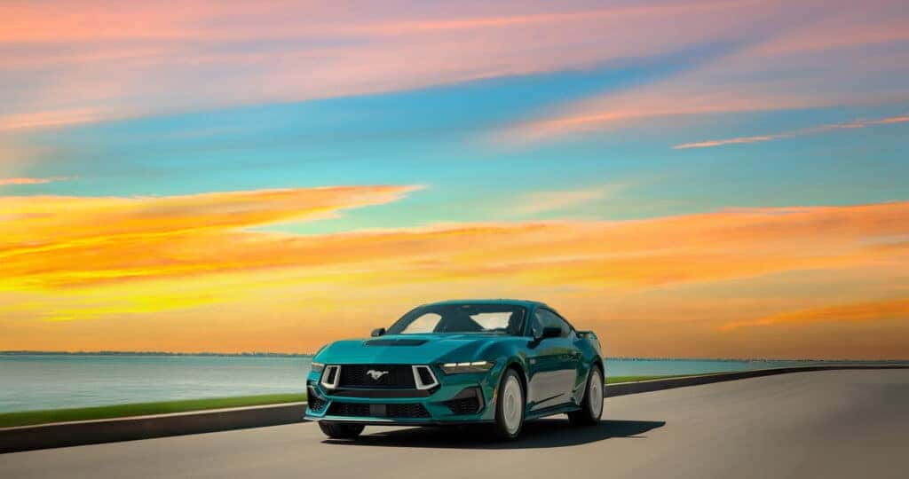 2026 Mustang FX Package driving down highway next to a lake with a blurry background