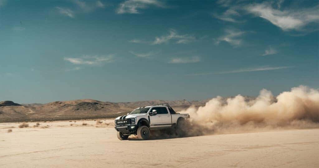 Shelby F-250 Super Baja sliding through a dry lake bed in the desert