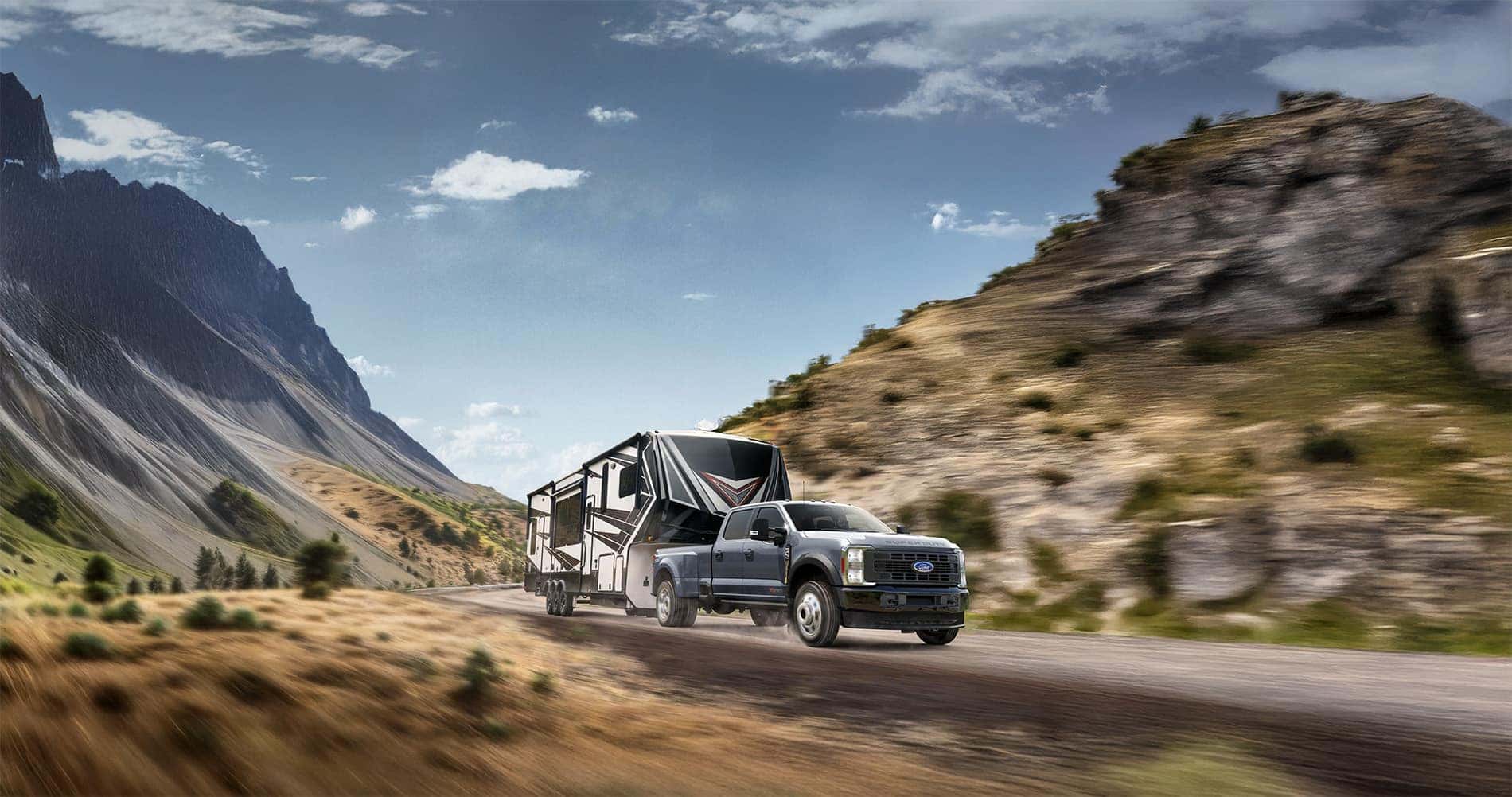 2026 Ford F-450 Platinum pulling a 4th wheel camper through the mountains