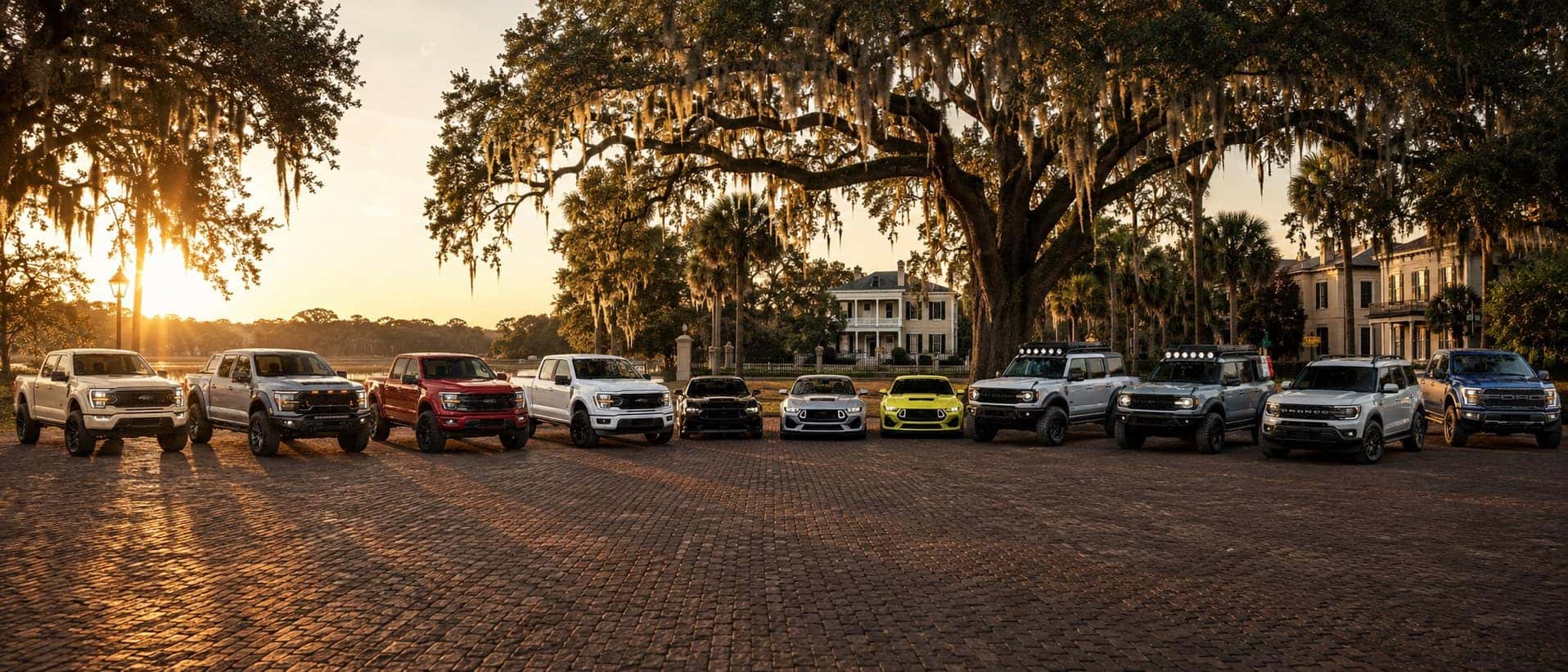 Ford trucks, RTR Mustangs, Bronco RTR models, and an F-150 Raptor beneath moss-draped oaks in Savannah, Georgia.