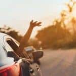 person in car with hand out the window