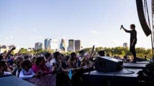 singer and crowd at Basilica Block Party with city in the background