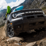 2024 Ford Bronco Sport navigating rugged outdoor terrain, showcasing off-road capability and durable design for adventure seekers.