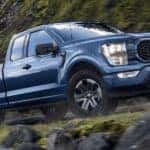 A blue 2023 Ford F-150 STX is shown from the side.