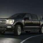 A black 2023 Ford F-150 Lariat Limited is shown towing a trailer after visiting aFord F-150 dealer near Dunwoody, GA.