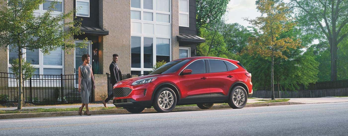 A red 2022 Ford Escape is shown from the side on a city street.