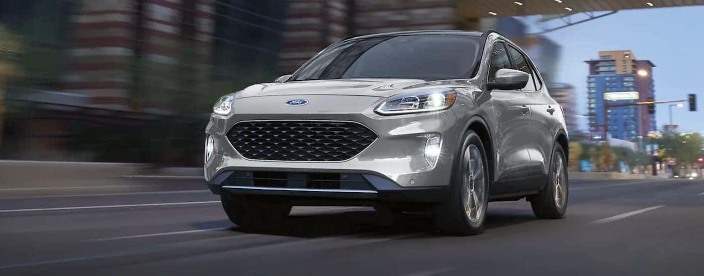 A silver 2021 Ford Escape is shown driving in a city.
