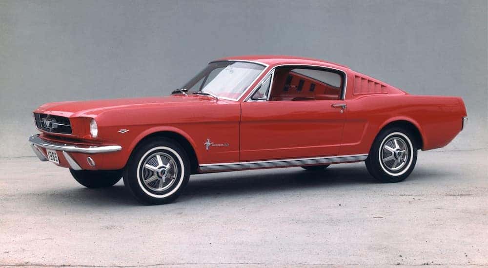 A red 1965 Ford Mustang is shown angled left.