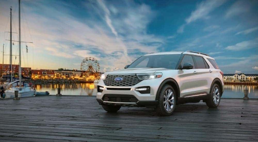 A white 2024 Ford Explorer is shown parked on a dock.