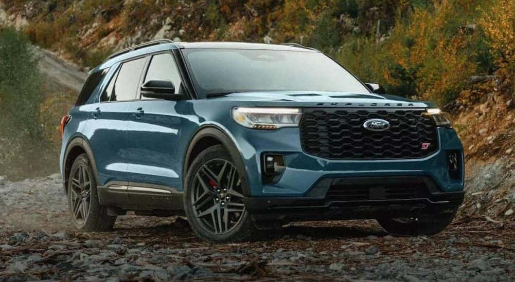 A blue 2025 Ford Explorer ST is shown parked off-road.
