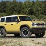 A yellow 2024 Ford Bronco Heritage Limited Edition is shown off-road.
