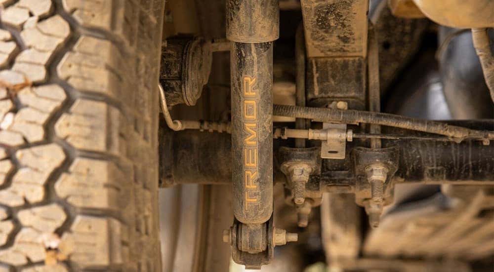 A close-up on the rear shock of a 2024 Ford F-150 Tremor is shown on lifted trucks for sale.