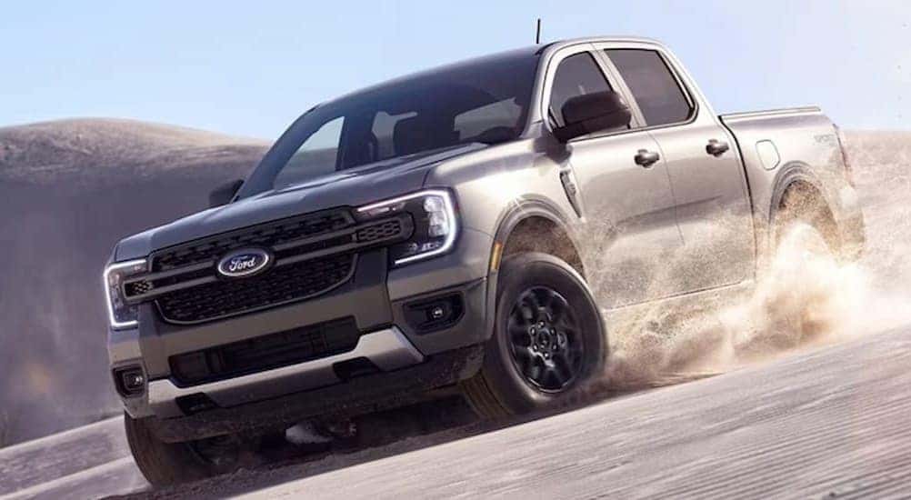 A silver 2024 Ford Ranger is shown driving off-road.