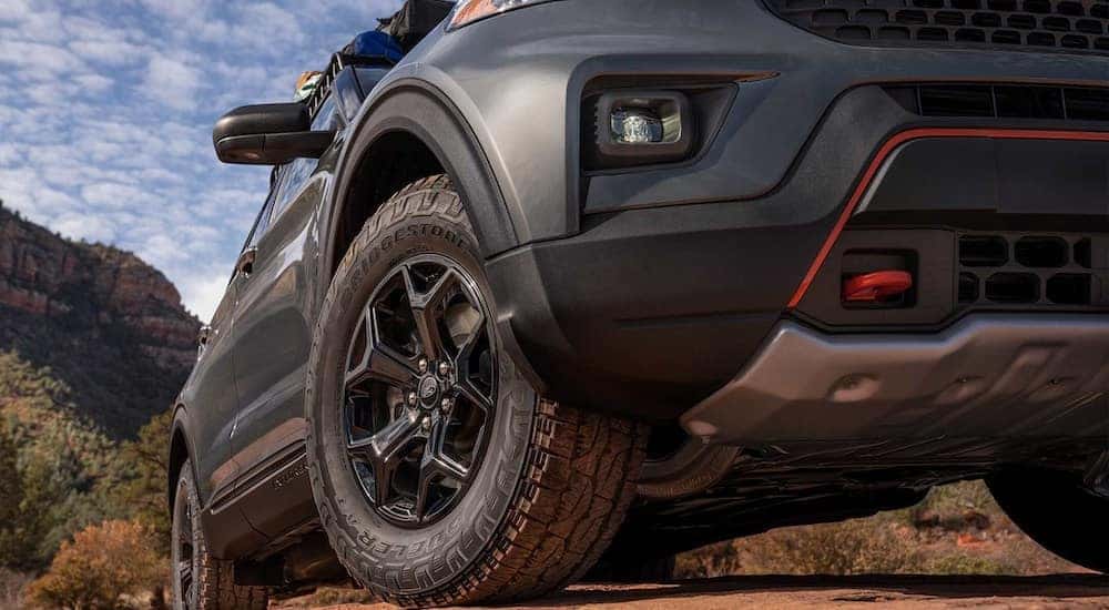 Low angle view of the front wheels of a black 2024 Ford Explorer for sale.