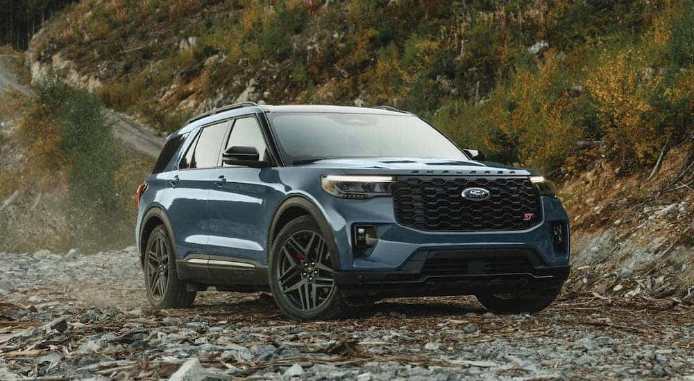 A blue 2025 Ford Explorer ST-Line parked off-road and angled right.