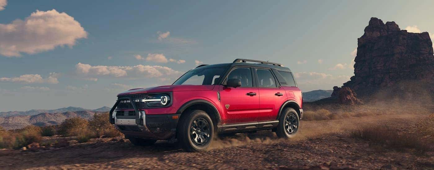 A red 2025 Ford Bronco Sport Badlands is shown driving off-road.