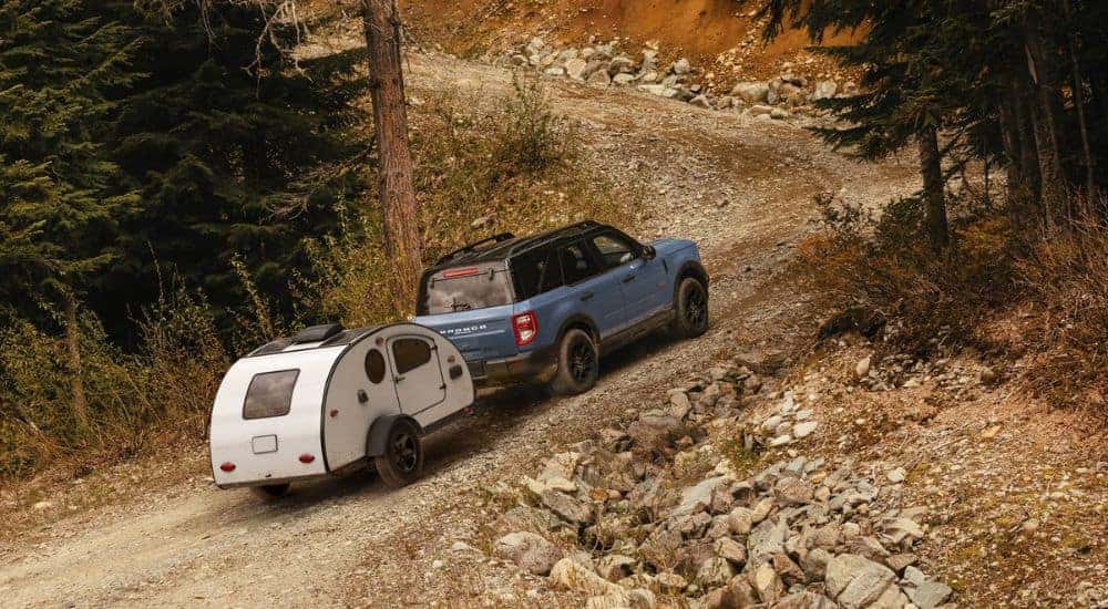Overhead view of a blue 2025 Ford Bronco Sport Badlands towing a trailer up a rocky hill.