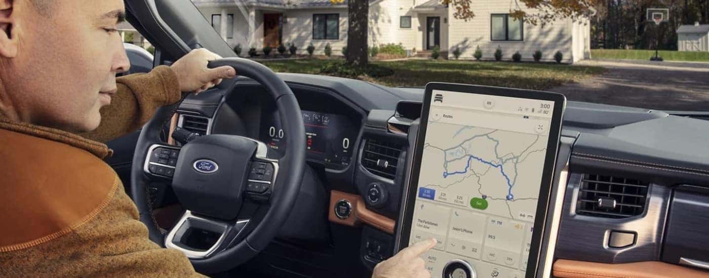 A person is shown using the infotainment screen in 2023 Ford Expedition.