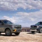 A green 2025 Ford Expedition Tremor and blue 2025 Ford Expedition Platinum parked off-road.