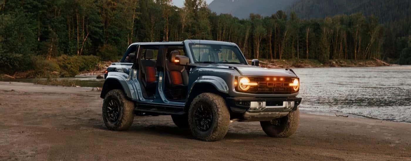 A blue 2025 Ford Bronco Raptor parked off-road.