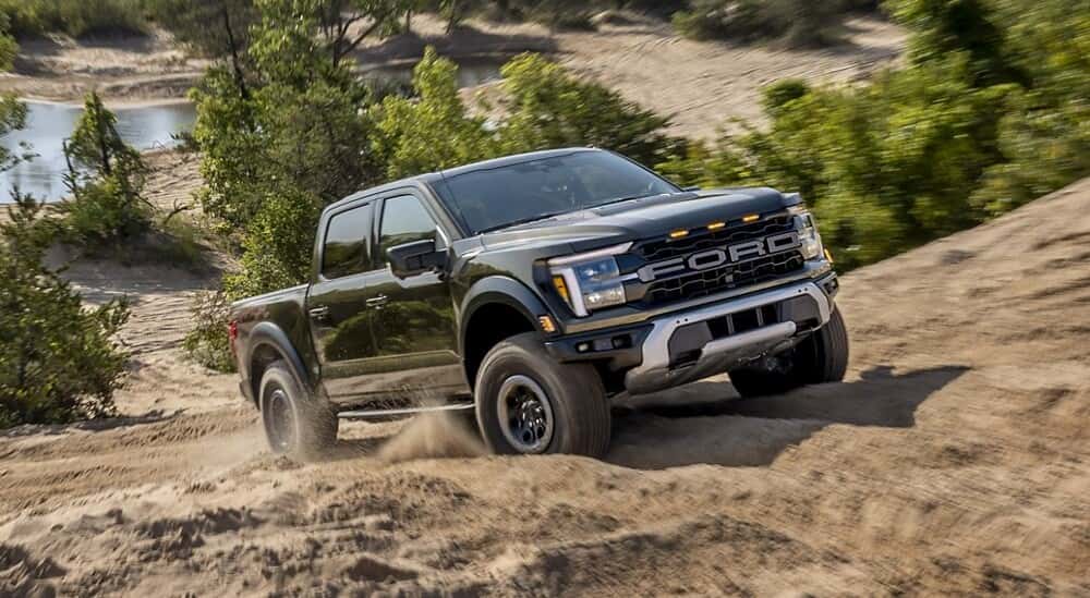 A black 2025 Ford F-150 Raptor off-roading.