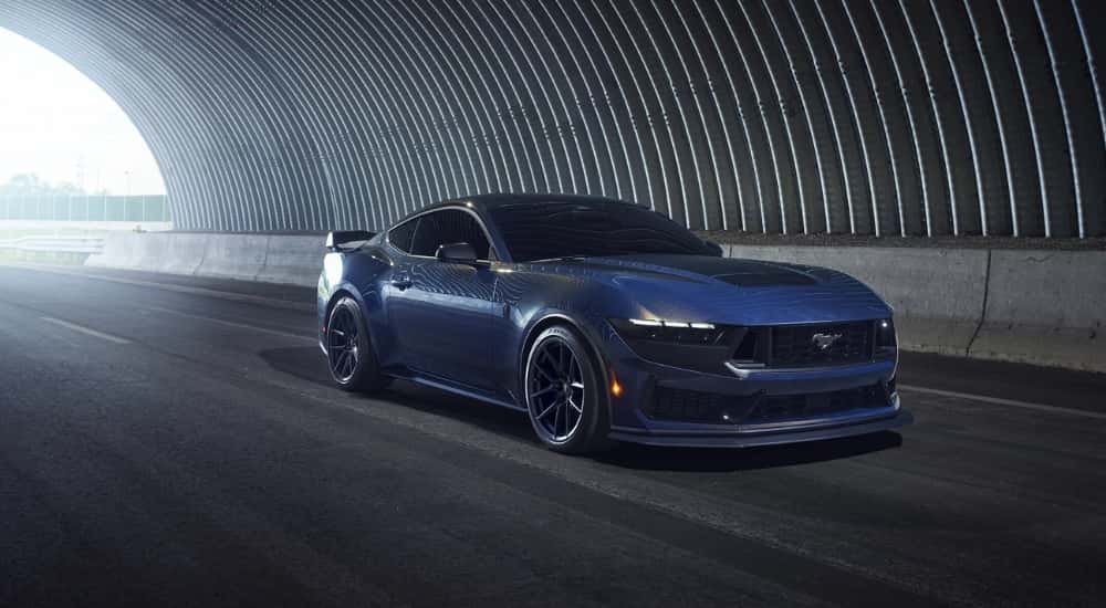 A blue 2025 Ford Mustang Dark Horse driving through a tunnel.