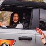 A person driving in a silver 2025 Ford Bronco.