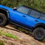 A blue 2025 Ford Bronco off-roading on a trail