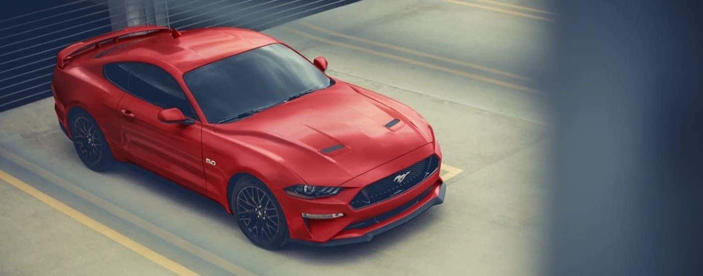 A red 2023 Ford Mustang GT is shown at a parking garage after leaving a Ford dealer.