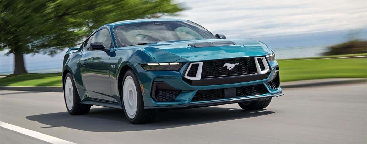 A green 2026 Ford Mustang GT Premium FX driving to a Ford dealer near Alpharetta.
