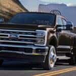 A black 2025 Ford Super Duty towing a horse trailer behind it