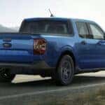 A blue 2025 Ford Maverick for sale in Atlanta driving down a highway