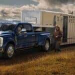 A blue 2026 Ford Super Duty towing a horse trailer.