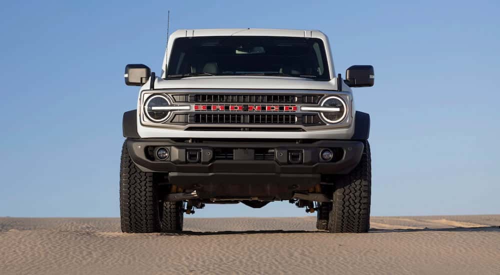 Front of a white 2026 Ford Bronco 60th Anniversary Edition parked off-road.