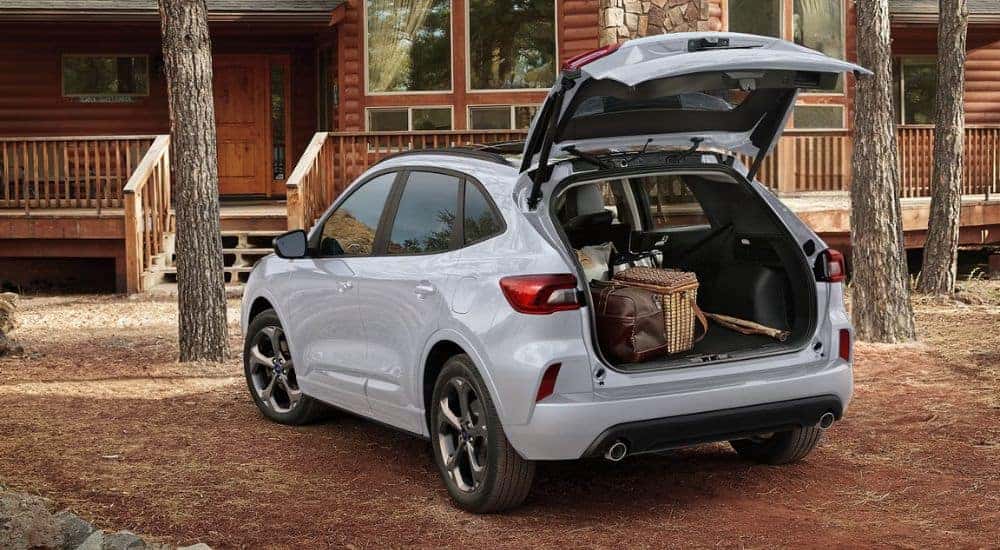 White 2026 Ford Escape with the power liftgate open at a cabin.