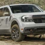 A white 2023 Ford Maverick Tremor is shown off-roading after leaving a Ford Truck dealer.