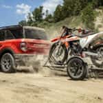 A red 2021 used Ford Bronco Sport for sale is shown towing dirt bikes.