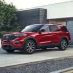 A red 2023 Ford Explorer is shown parked in a driveway after visiting a Monroe Ford dealer.