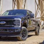 A blue 2023 Ford F-250 STX is shown parked at a construction site after leaving a Ford dealer near Covington.