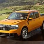 An orange 2024 Ford Maverick is shown driving on a sunny day.
