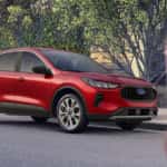 A person is shown walking away from a red 2025 Ford Escape.