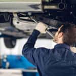 A mechanic near you is shown working on a vehicle on a lift.