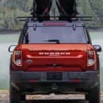 A red 2024 Ford Bronco Sport is shown parked near a lake.