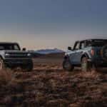 Two blue 2024 Ford Bronco Badlands are shown facing opposite directions.
