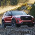 A red 2025 Ford Explorer ST is shown parked off-road.