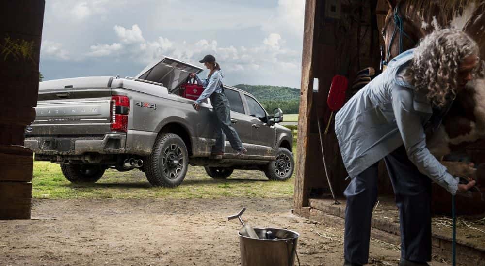 A silver 2025 Ford F-250 Platinum parked outside a barn.