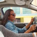 Two smiling women driving in a 2021 Ford EcoSport after getting engine repairs done.